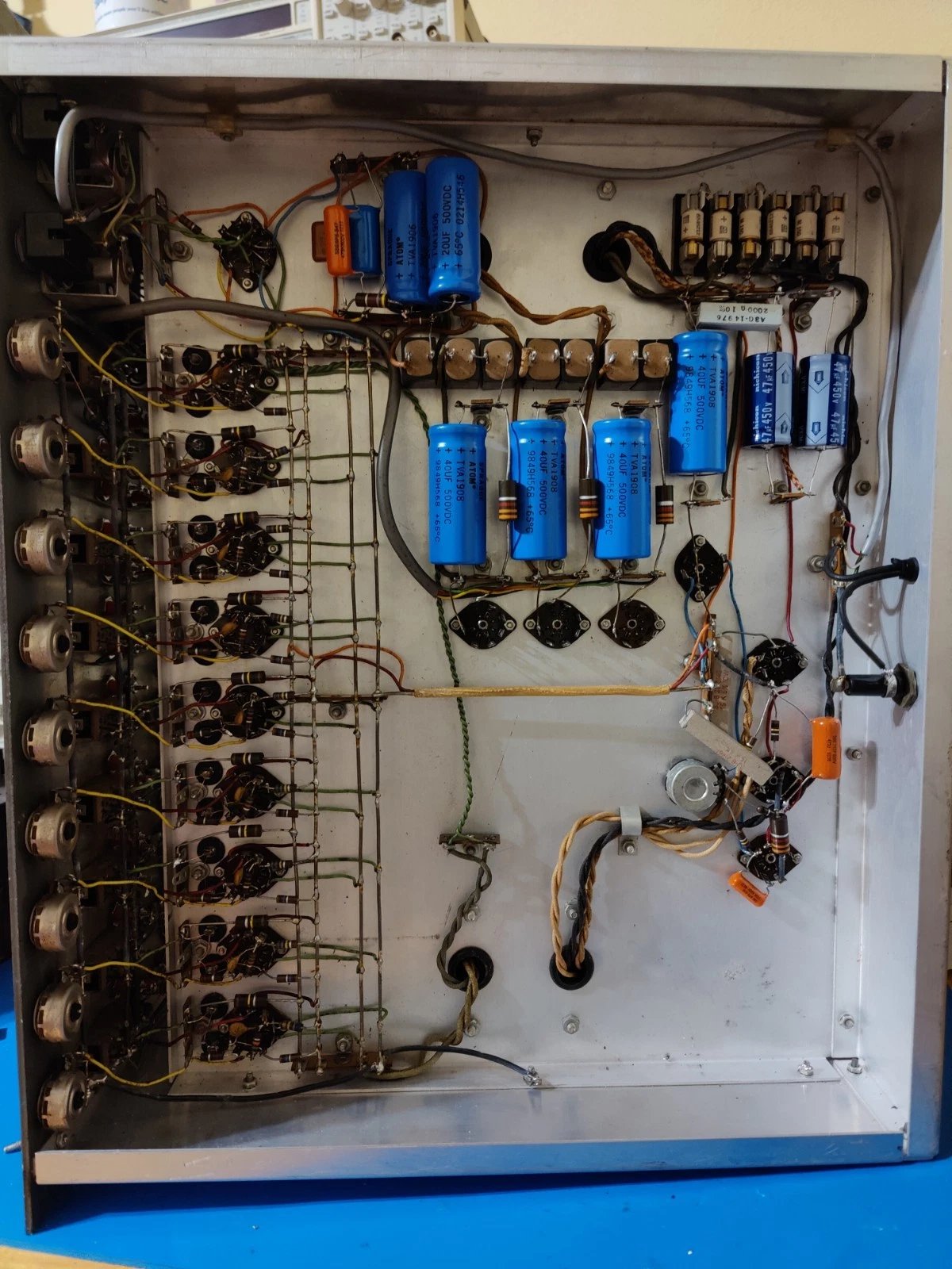 Chassis interior with all nine amplifier modules visible, tubes in sockets, wiring harness to front panel binding posts.