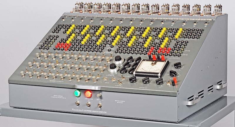 The ES-400 front panel fully restored, showing the banana-jack patch field with yellow and red patch cords installed across the computing rows. Fifteen ES-201 op-amp modules visible along the top edge.