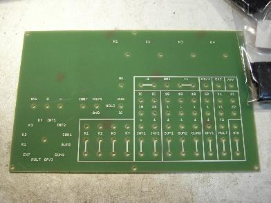 The machine's bare front panel, cut from green printed-circuit-board material, with the meter cut-out, potentiometer holes and the full grid of patching holes drilled but unpopulated.